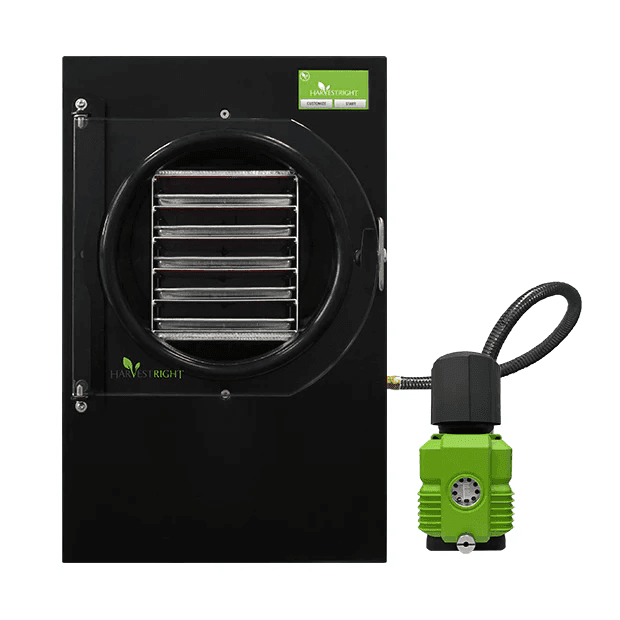 Front view of a black Harvest Right freeze dryer with a closed door and attached green vacuum pump.