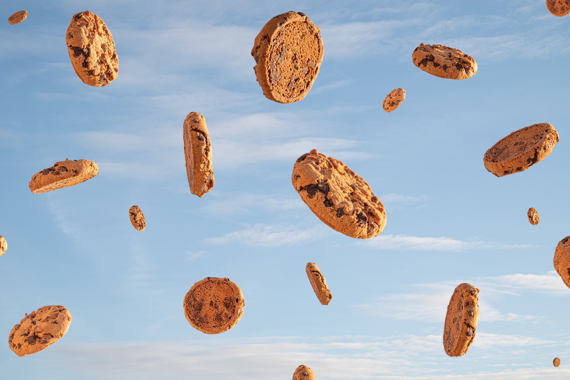 Chocolate biscuit cookies flying on a blue sky with clouds
